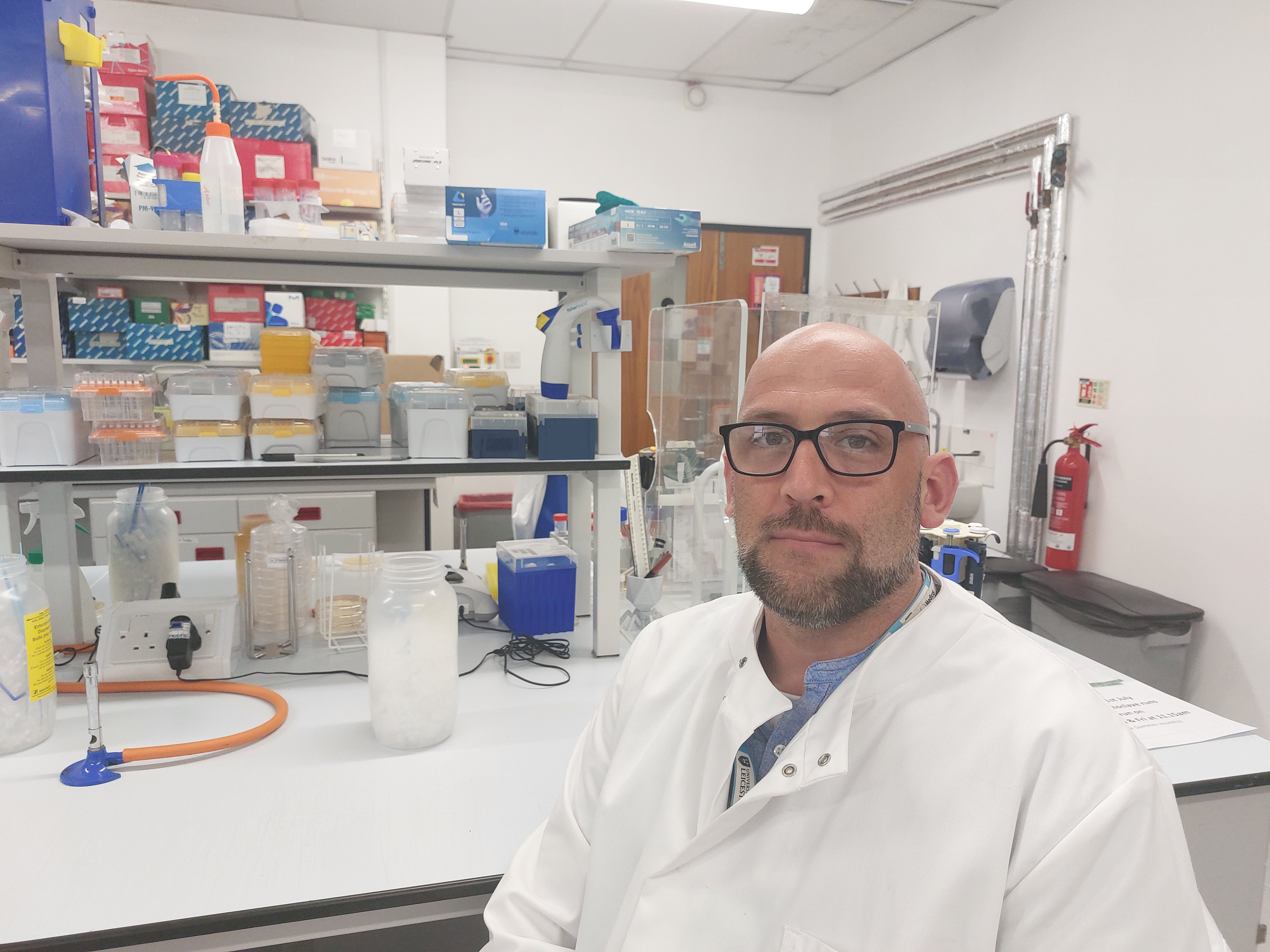 Dr Andrew Millard photographed sitting in the lab
